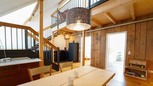 A wooden interior with a dining table, chairs, a staircase, and a radio. - Apartment 'Wendlingen 3' with Shared Terrace, Balcony and Wi-Fi (Freiburg im Breisgau)