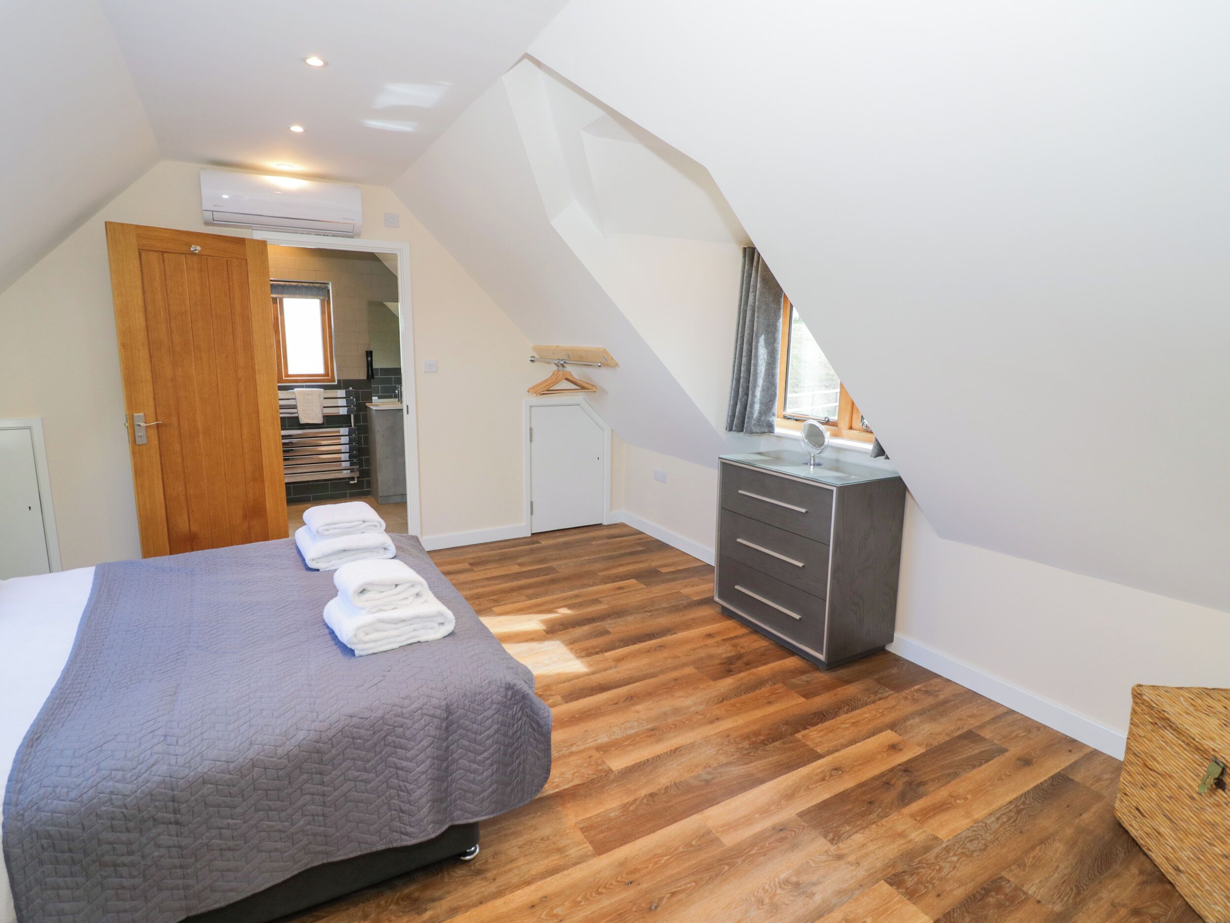 Un dormitorio con cama, cómoda y espejo.
