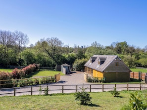 A rural property with a main house, a smaller shed, and a fenced area with greenery. - The Coach House (Banbury)