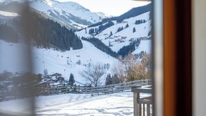 A snowy mountain landscape with a wooden bridge and ski slopes. - Superb apartment on the slopes with terrace (Hinterglemm)