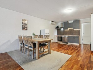 A compact kitchen with modern appliances, a dining area with wooden chairs, and a small refrigerator. - "Ilsabe" - 25km from the sea by Interhome (Agerskov)