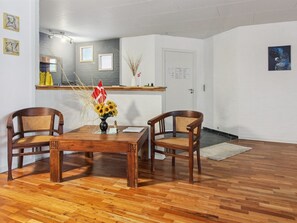 Un coin repas avec une table en bois, deux chaises et un vase rempli de tournesols.