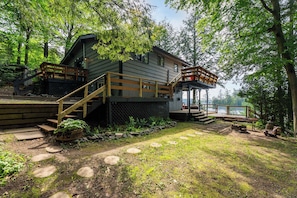 Une cabane dotée d’une terrasse, d’un escalier extérieur et offrant une vue sur un lac.