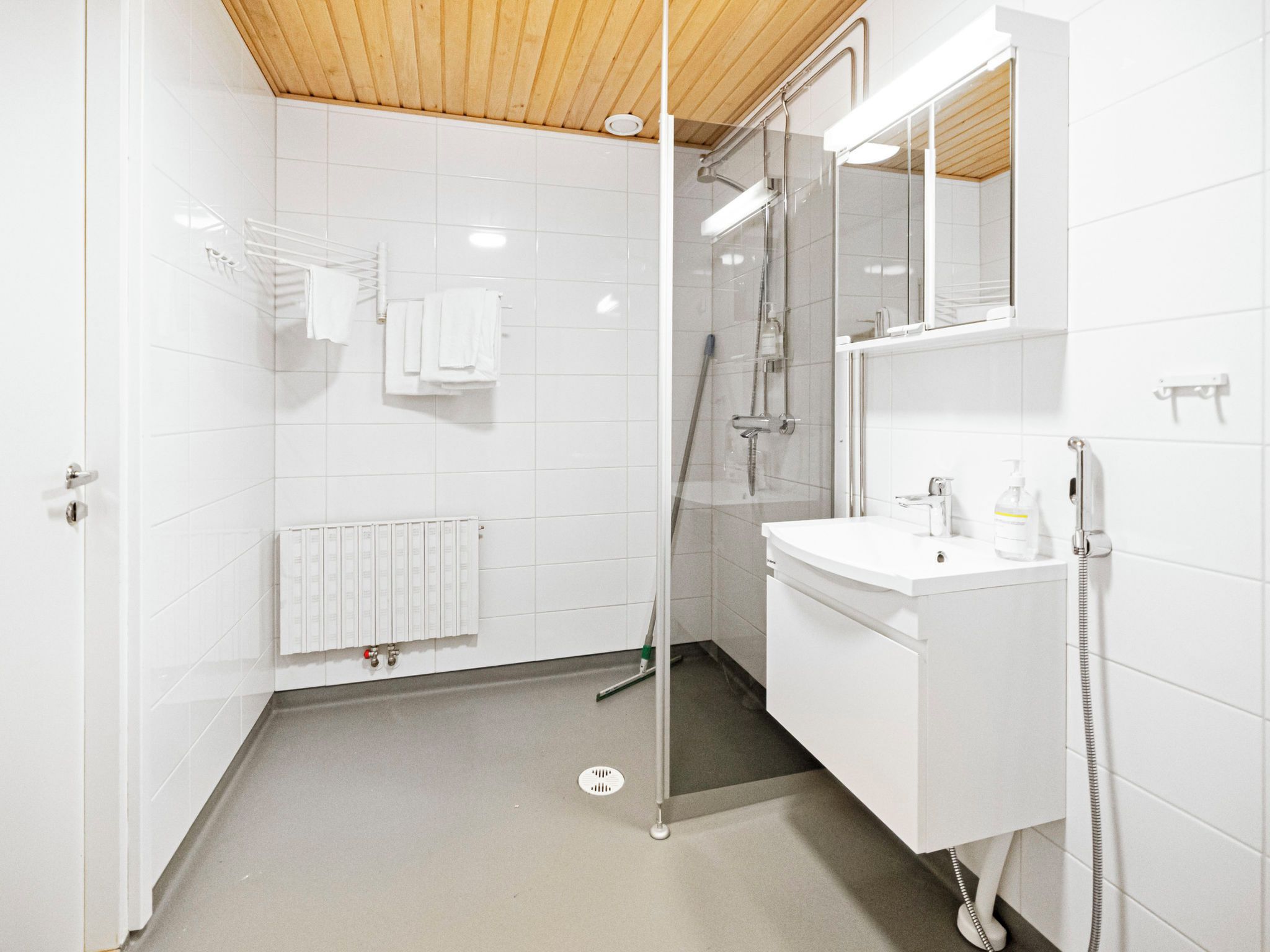 Une salle de bain moderne avec une douche à parois de verre, un lavabo blanc et un miroir au-dessus.