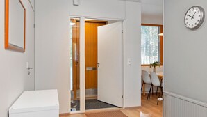 Una habitación moderna con una puerta de madera, un radiador blanco y un reloj en la pared.