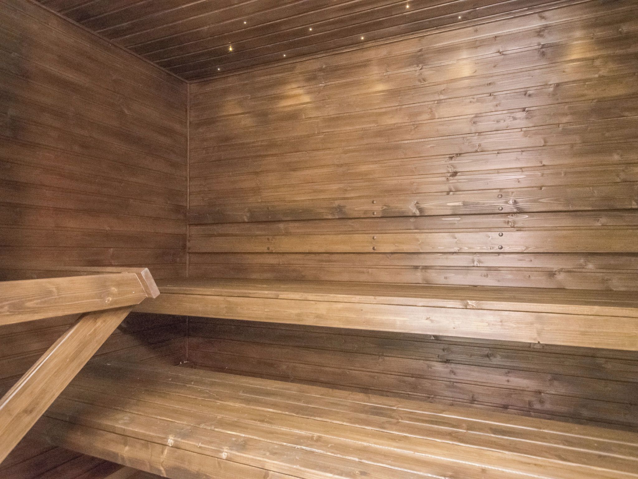 A wooden interior with benches and a sloped ceiling.
