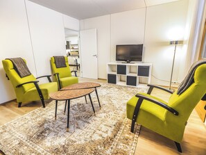 Ett modernt vardagsrum med en soffgrupp, ett soffbord och en tv som står på ett TV-bord.