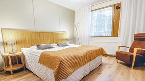 Une chambre moderne avec un lit, une table de chevet, une lampe, une chaise et une fenêtre avec des rideaux.