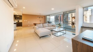 A modern living room with a sectional sofa, a coffee table, and a dining area.