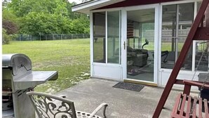 Un patio con una parrilla, una silla de metal y un columpio.