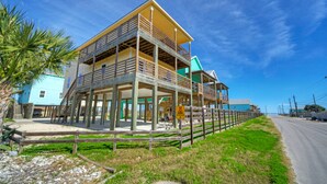A multi-story building with a balcony, a staircase, and a view of the beach. - 6BDR, Balcony w/ Bay View, Shared Pool + Boat Dock | Keeper Red by AvantStay (Corpus Christi)