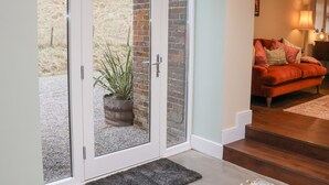 Ein modernes Interieur mit einer Schiebetür zum Patio, einem roten Sofa und einer Lampe.