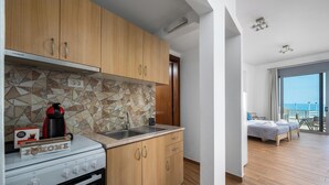 A modern kitchen with wooden cabinets, a gas stove, and a coffee maker.