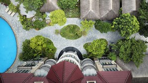 An aerial view of a hotel with a swimming pool, lush greenery, and thatched-roof structures. - Indochine Boutique Hotel Ninh Binh (Nam Hoa Lu)