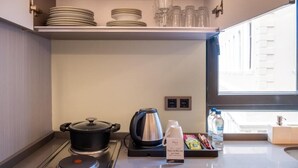 A compact kitchenette with a stove, kettle, and a tray of snacks. - The Platine Plus Suite (Istanbul)