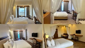 Una habitación de hotel con una cama grande, un escritorio, una silla, un televisor y vistas al exterior.