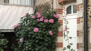 A stone building with a white door, a small staircase, and a wall-mounted light fixture. - Villa Classée Face Mer, Petit Jardin , Veranda et Terrasse Ensoleillée, 120 m2, (La Baule-Escoublac)