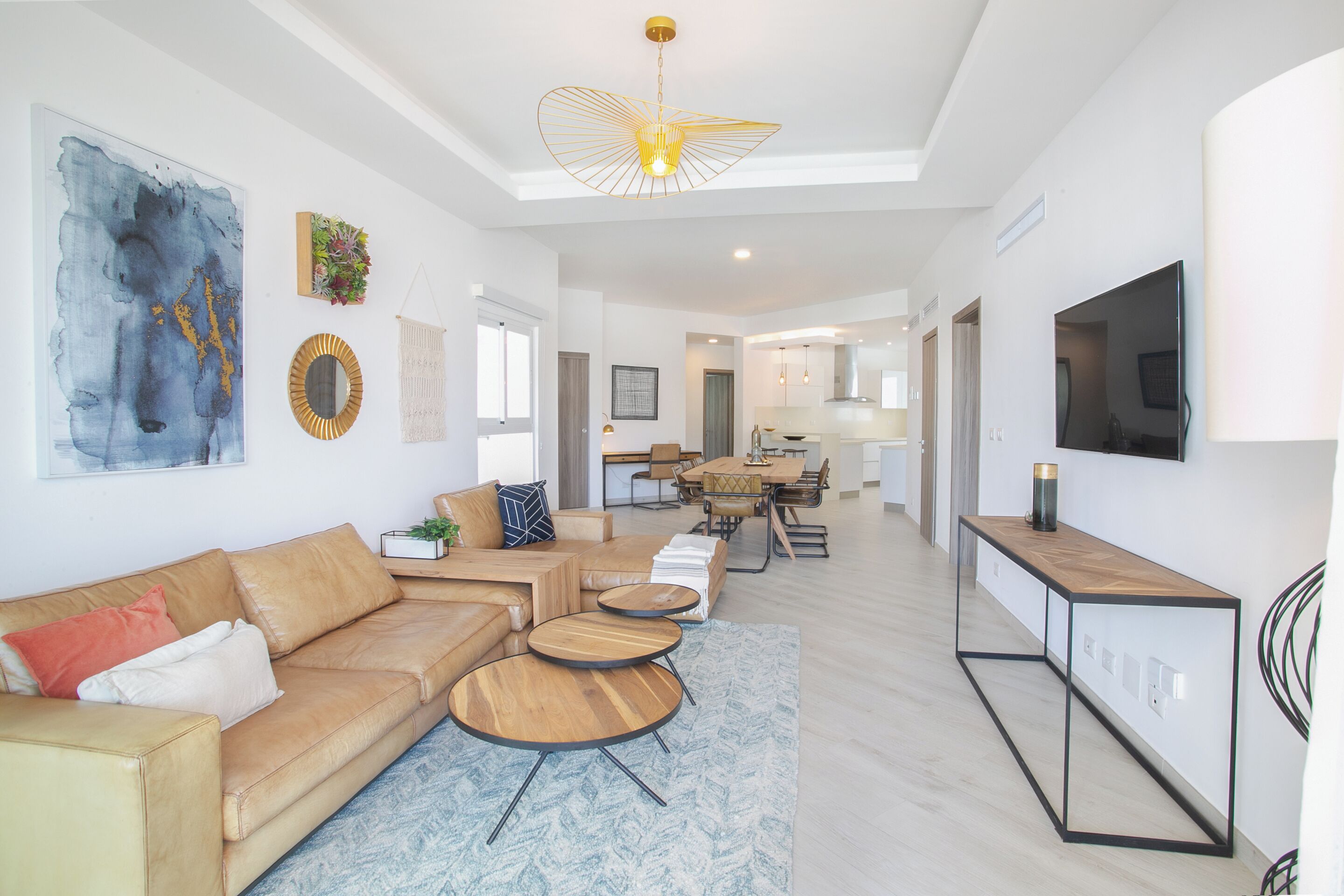 A modern living room with a sofa, coffee table, and a TV on a stand.