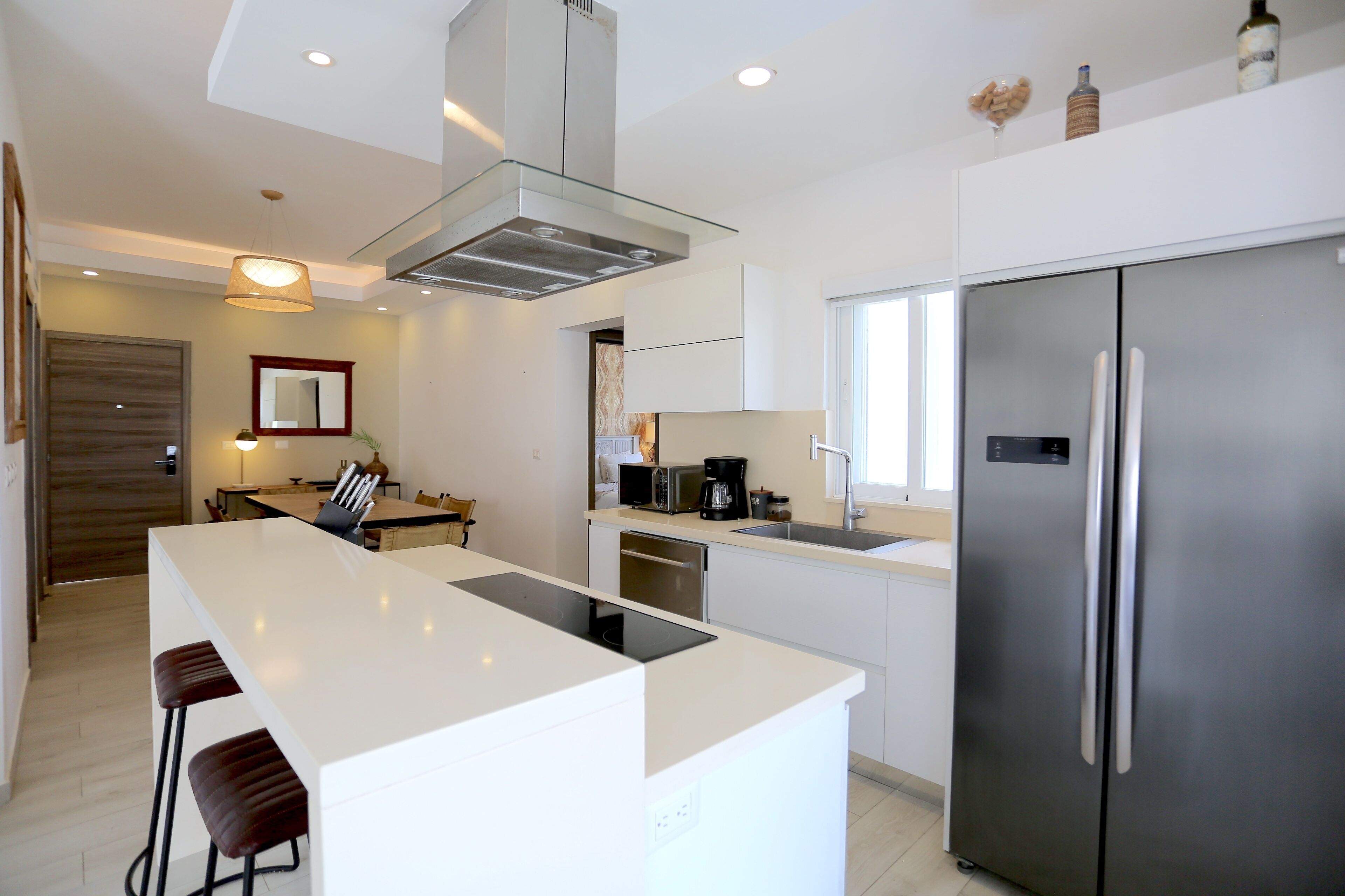 A modern kitchen with a central island, stainless steel appliances, and a dining area with a table and chairs.
