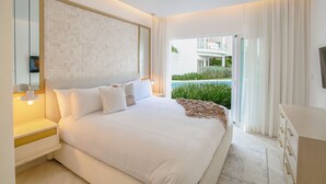 Une chambre moderne avec un grand lit, une table de chevet, une commode et une vue sur une piscine.