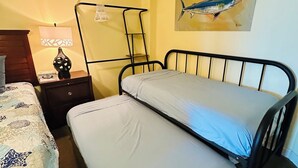 A bedroom with a bed, bedside table, lamp, and a wall painting. - Direct Oceanfront View with KingBed+Pools +GarageParking+Gym+InUnitWasher&Dryer (Myrtle Beach)