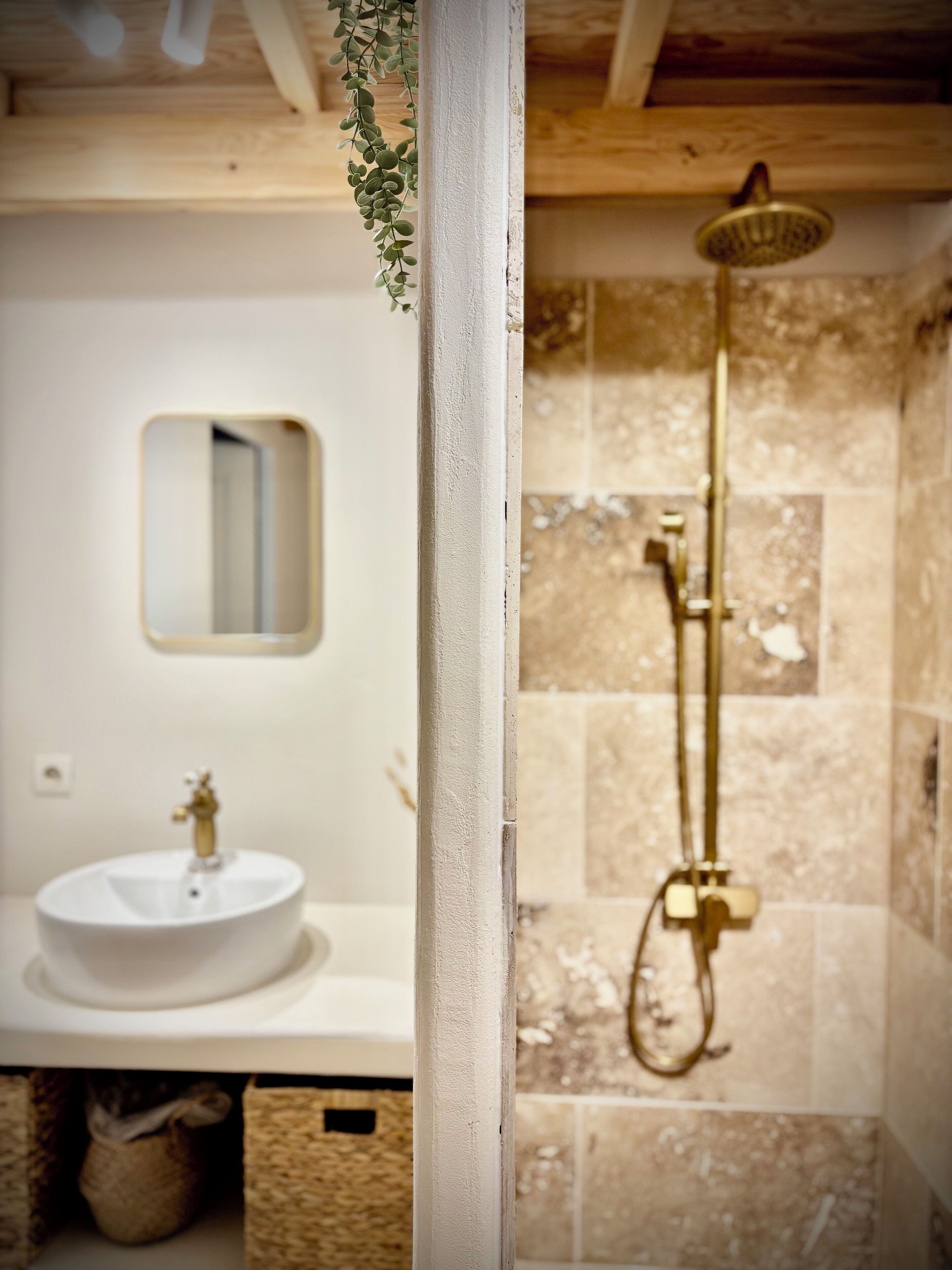 Une salle de bain avec un lavabo, un miroir et une douche.