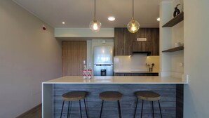 Una cucina moderna con isola centrale, mobili in legno e luci a sospensione.