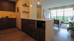 Una cucina moderna con mobili in legno, forno a microonde integrato e lampade a sospensione.