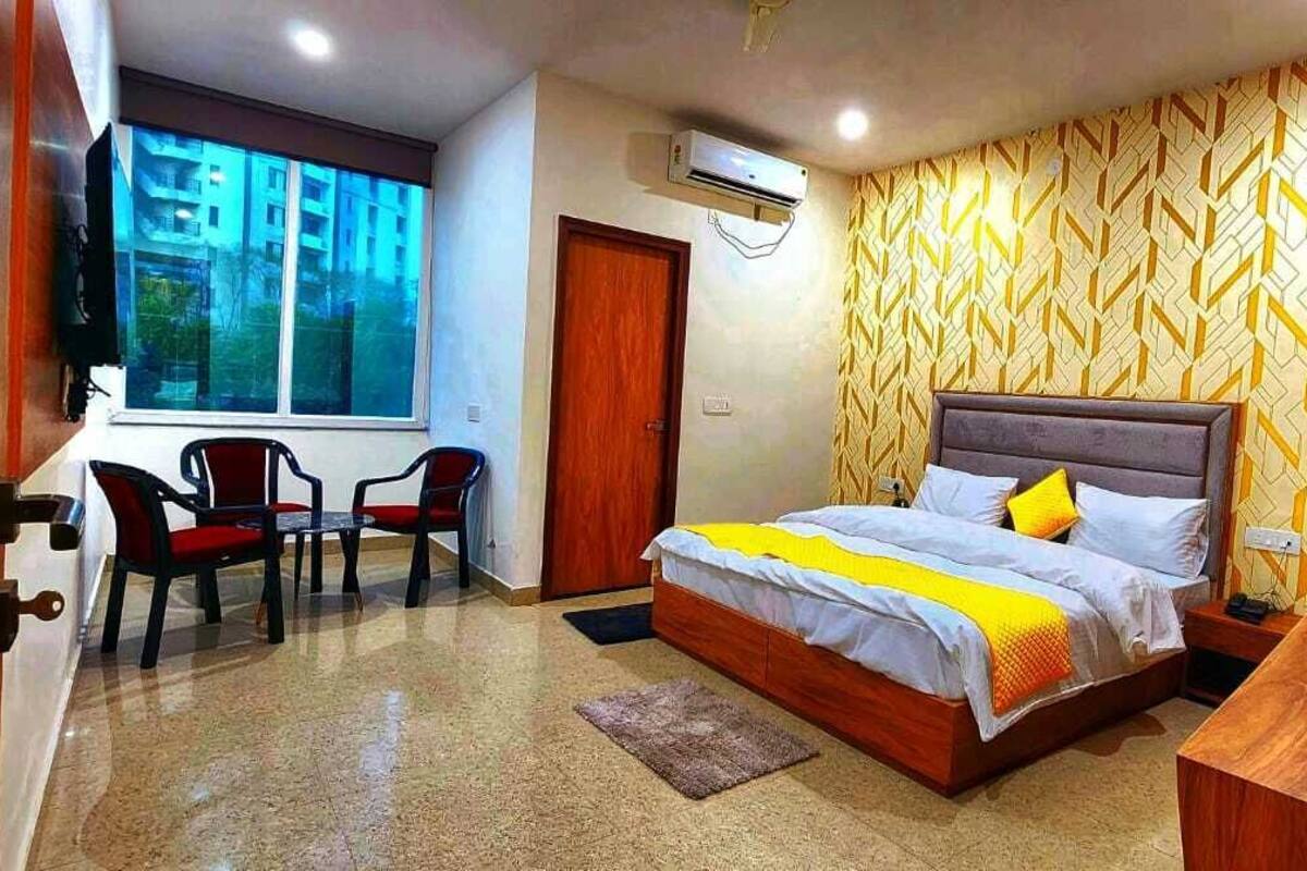 Un dormitorio con cama, escritorio, silla y ventana.