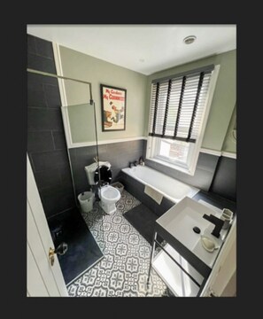 A bathroom with a toilet, bathtub, and sink. - 3 Bed Home - Sleeps 6, Garden, Pets and Very Central (Guildford)