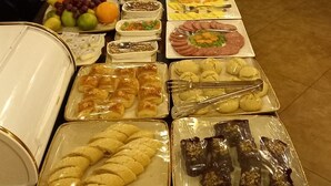 A buffet table with various food items and drinks. - Port Hotel (Baku)
