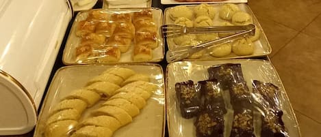 A buffet table with various food items and drinks.