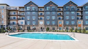 A modern multi-story hotel with a swimming pool in the courtyard. - Canandaigua Condo w/ Restaurant and Pool/Hot Tub (Canandaigua)