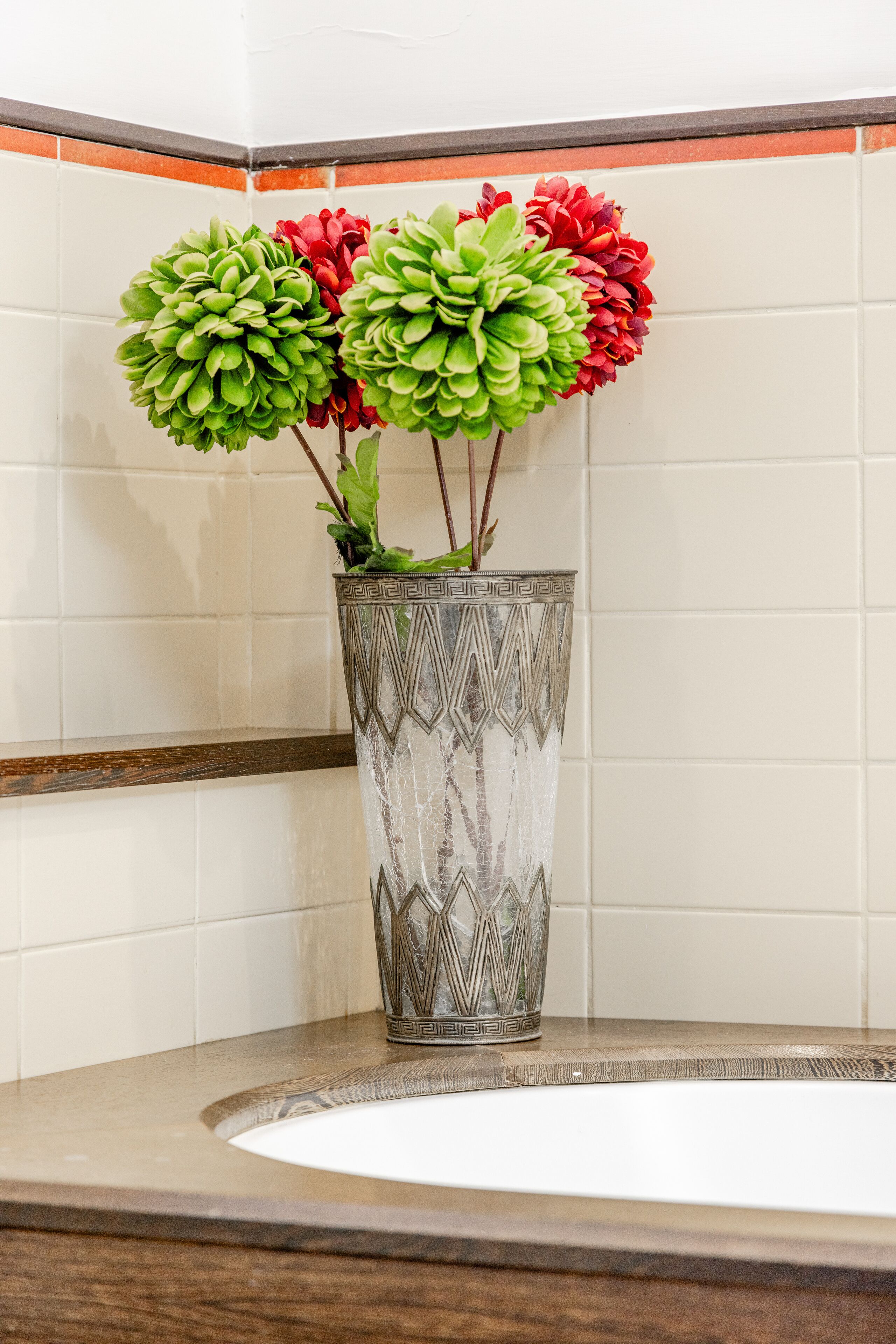 A decorative vase with a geometric pattern on a bathroom countertop.