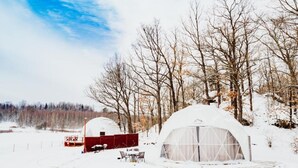 A snow-covered landscape with two dome-shaped yurts and a red barn. - Karkonoski Glamping 2 sleeps 5 (Lomnica)