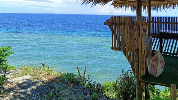 A thatched-roof structure with a view of the ocean. - Seaheart Guesthouse (Dauis)