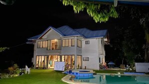 A two-story house with a swimming pool and a covered patio. - Seaheart Guesthouse (Dauis)