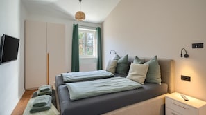 A modern bedroom with a bed, a TV, a bedside table, and a window with curtains. - Villa LeGro by Villas Guide (Rapavel)