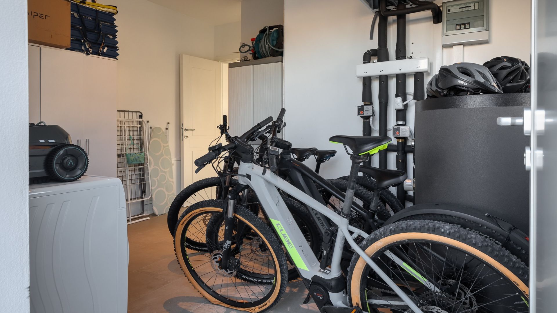 A narrow hallway with bicycles parked against the wall, a white door, and a radiator.