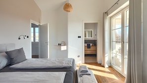 Una camera da letto con un letto, un comodino e vista sul bagno.