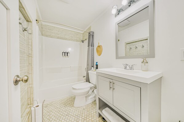A bathroom with a toilet, sink, and shower.