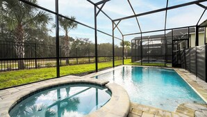 Ein Swimmingpool mit Whirlpool, umgeben von einem Metallzaun und Palmen.