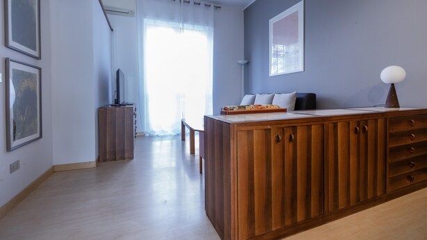 Una sala de estar moderna con un aparador de madera, un sofá y un televisor de pantalla plana.