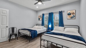 A bedroom with two single beds, a ceiling fan, a window with blinds, and a chair. - Charming Walkable 4 BR 2 5 BA Near Dtown Riverwalk (San Antonio)