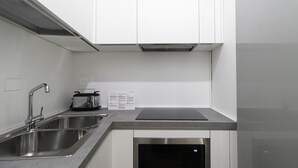 A modern kitchen with stainless steel appliances, a double sink, and a black cutting board on the countertop. - Italianway Comfort - Fabbri 12 D (Milan)