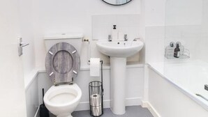 A modern bathroom with a toilet, sink, and mirror. - Stunning 1-bed Apartment in Birmingham (Birmingham)