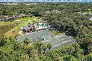 Vue aérienne d’un terrain de golf avec une piscine, entouré d’une végétation luxuriante et de zones résidentielles.