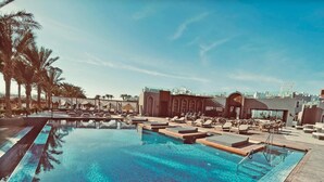 A large outdoor swimming pool with lounge areas and palm trees. - SUNRISE Tucana Resort - Posh Club (Makadi Bay)