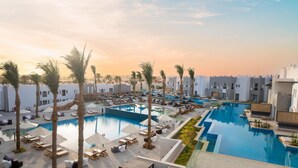 A resort with multiple swimming pools, palm trees, and modern architecture. - SUNRISE Tucana Resort - Posh Club (Makadi Bay)
