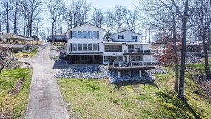 A two-story house with a large deck and a covered patio area.